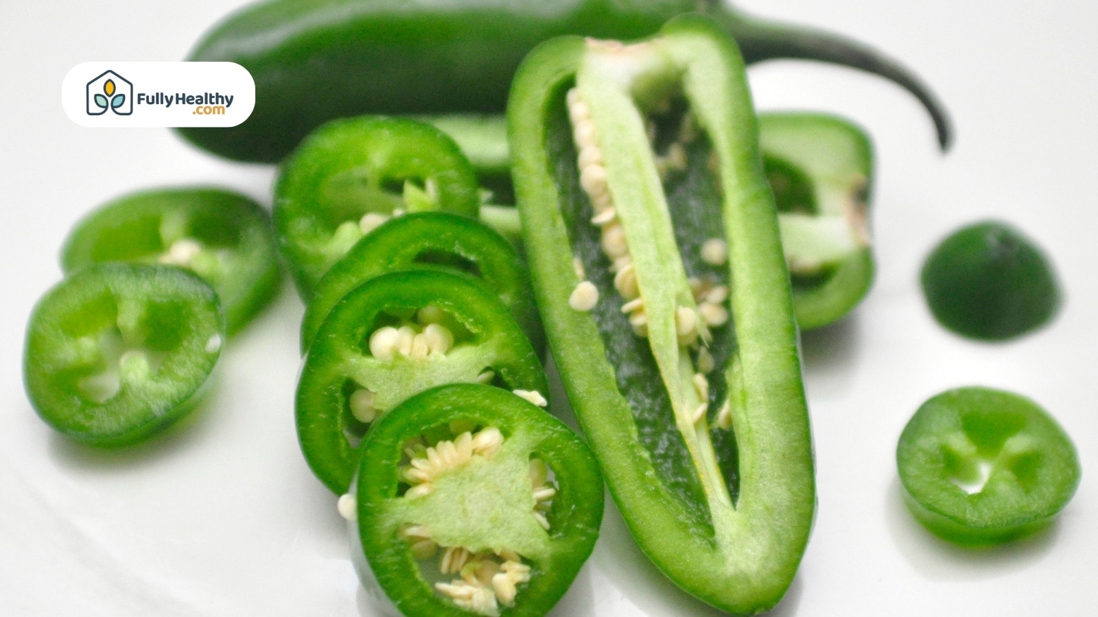 Whole and sliced jalapeños displayed on a white background