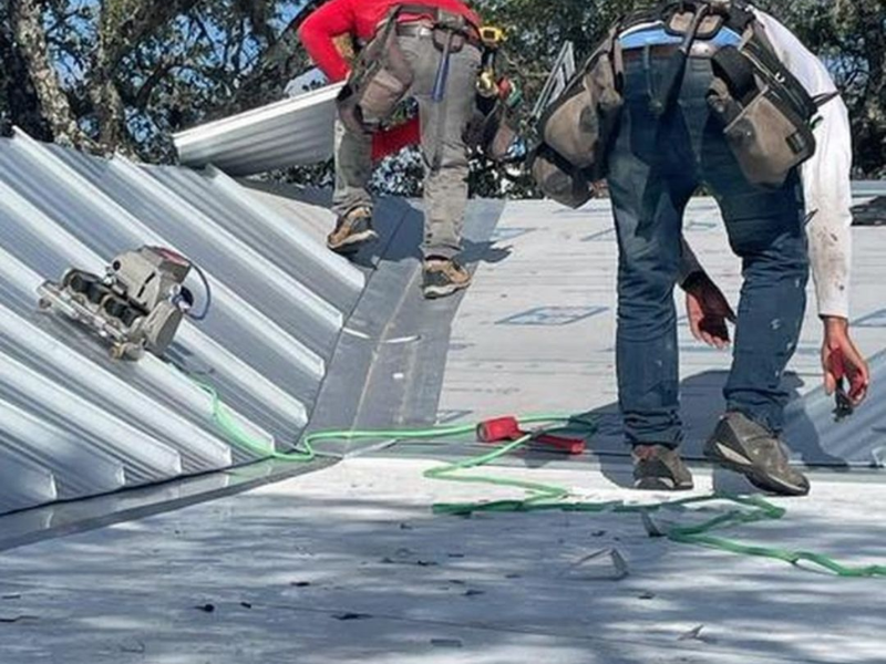 An image showing Spartan Roofing & Siding installing a standing seam metal roof in San Antonio, TX.