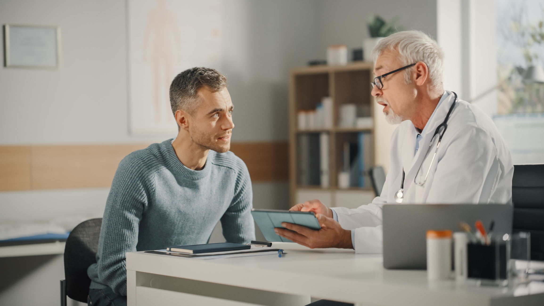 Doctor at his desk explaining medical tests to his patient. 