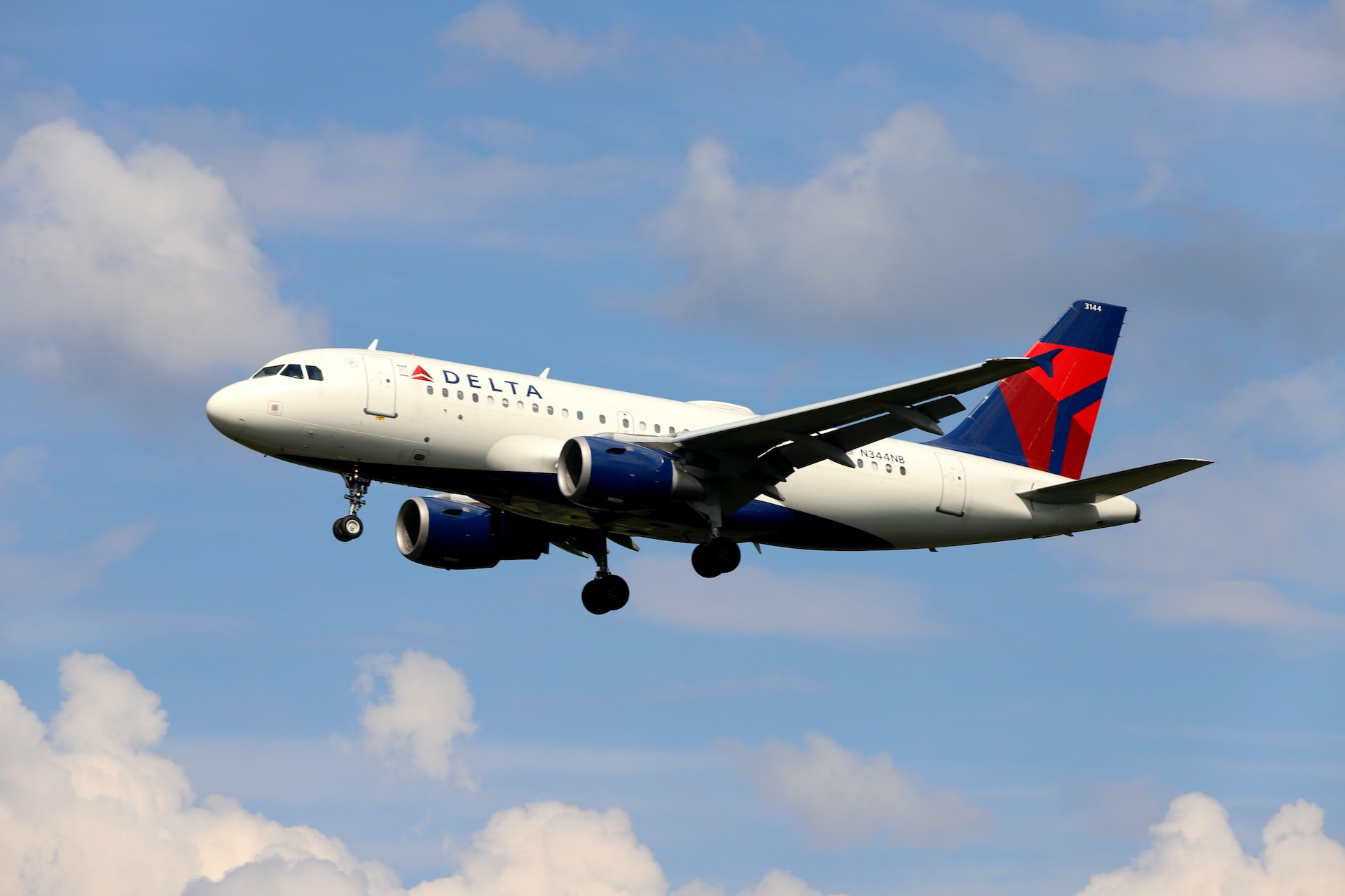 A small Delta Airlines aircraft landing on a sunny day.