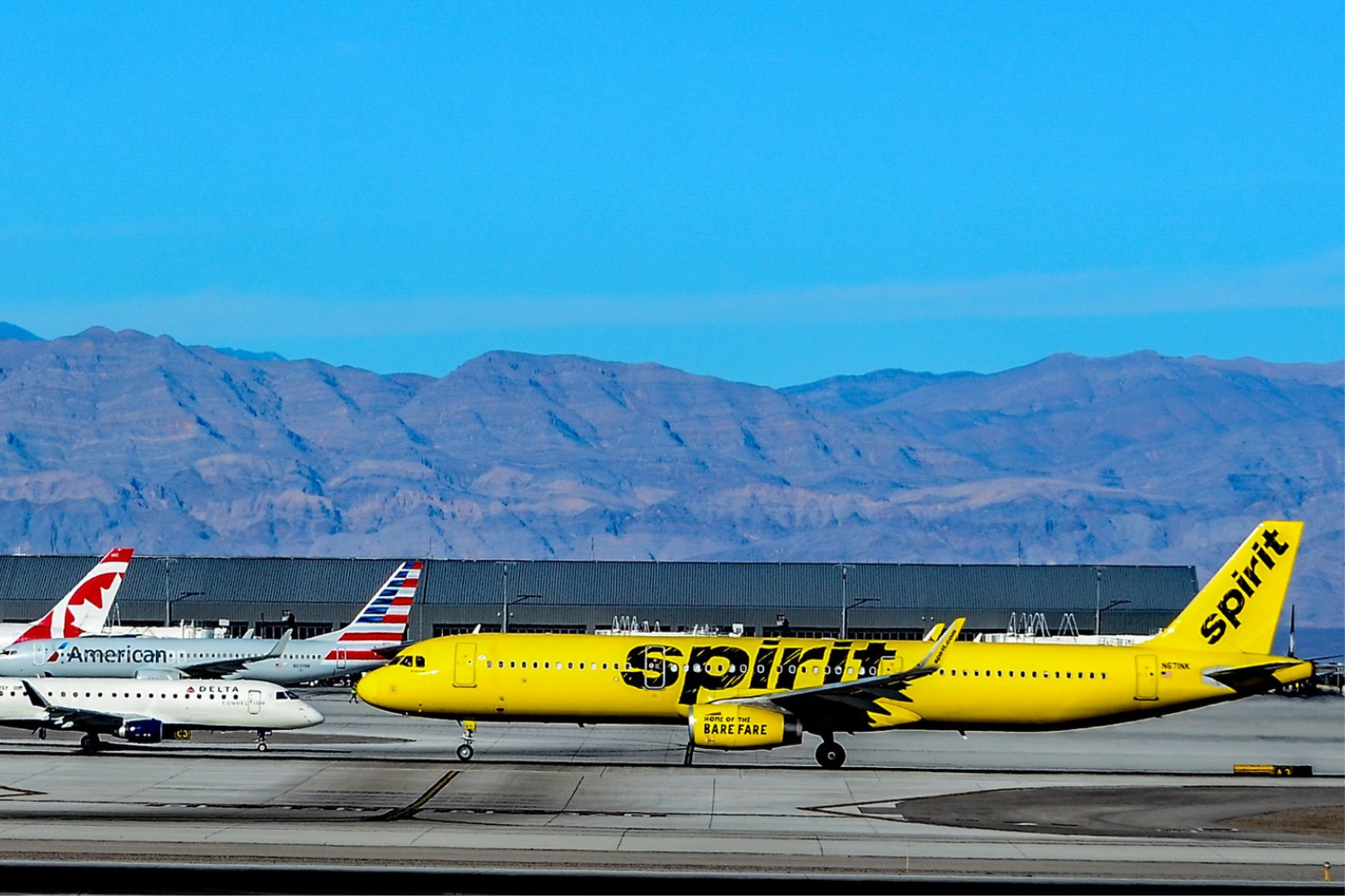 a yellow spirit flight and a white american airlines flight at an airport: why are spirit and frontier so cheap