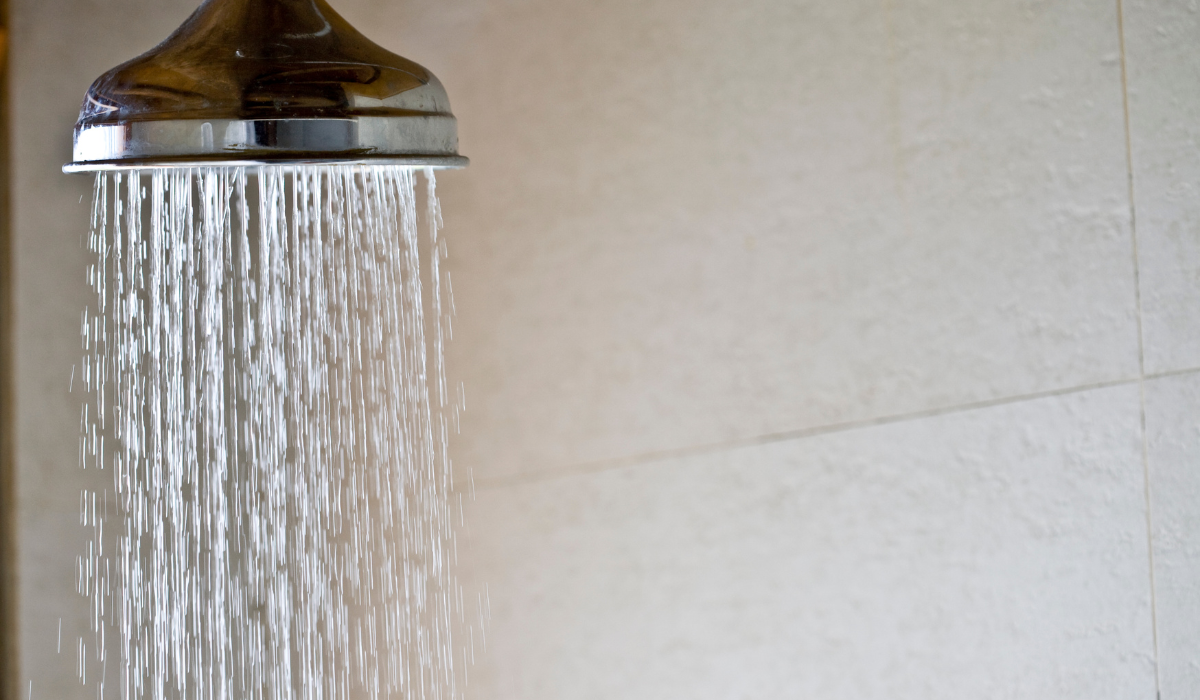 Rain shower head with chrome metal surface - water flowing