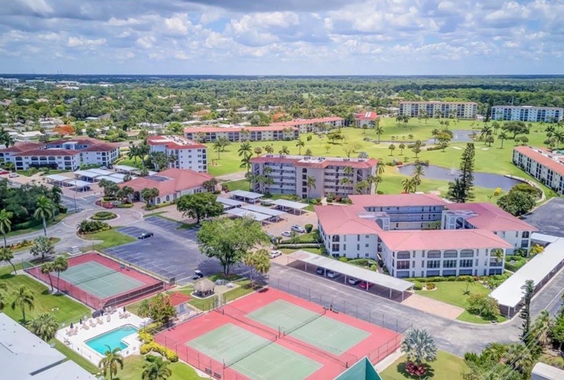 An aerial view of High Point Country Club showcases its beautiful golf course, cozy condominiums, and exceptional community amenities, all surrounded by lush landscaping. This image highlights the peaceful golf course vistas and the welcoming atmosphere of this private country club, perfect for those seeking an active lifestyle in Naples.