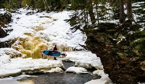 carrying an inflatable paddle board through the snow