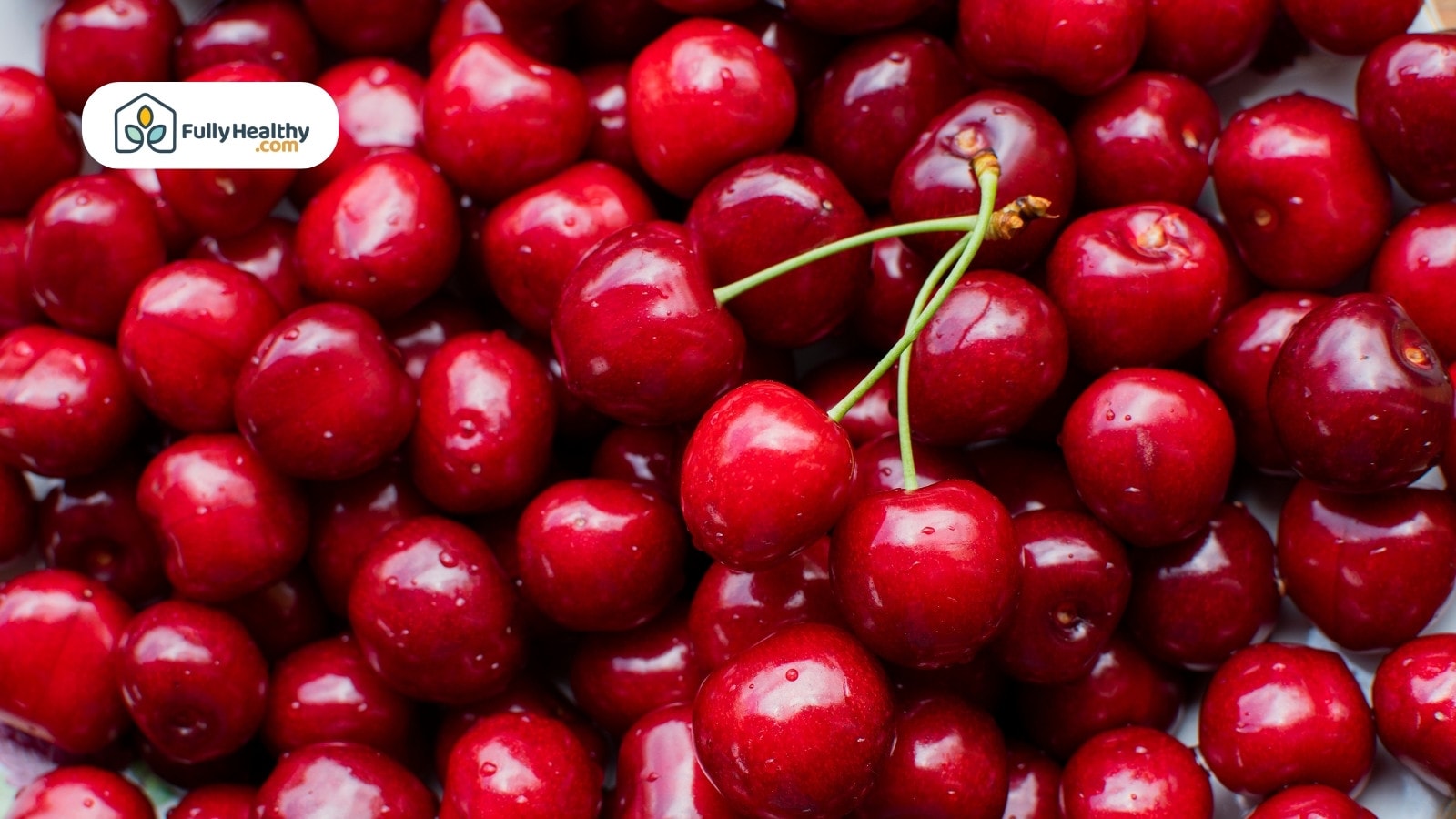 Close-up of shiny fresh cherries with water droplets on surface.