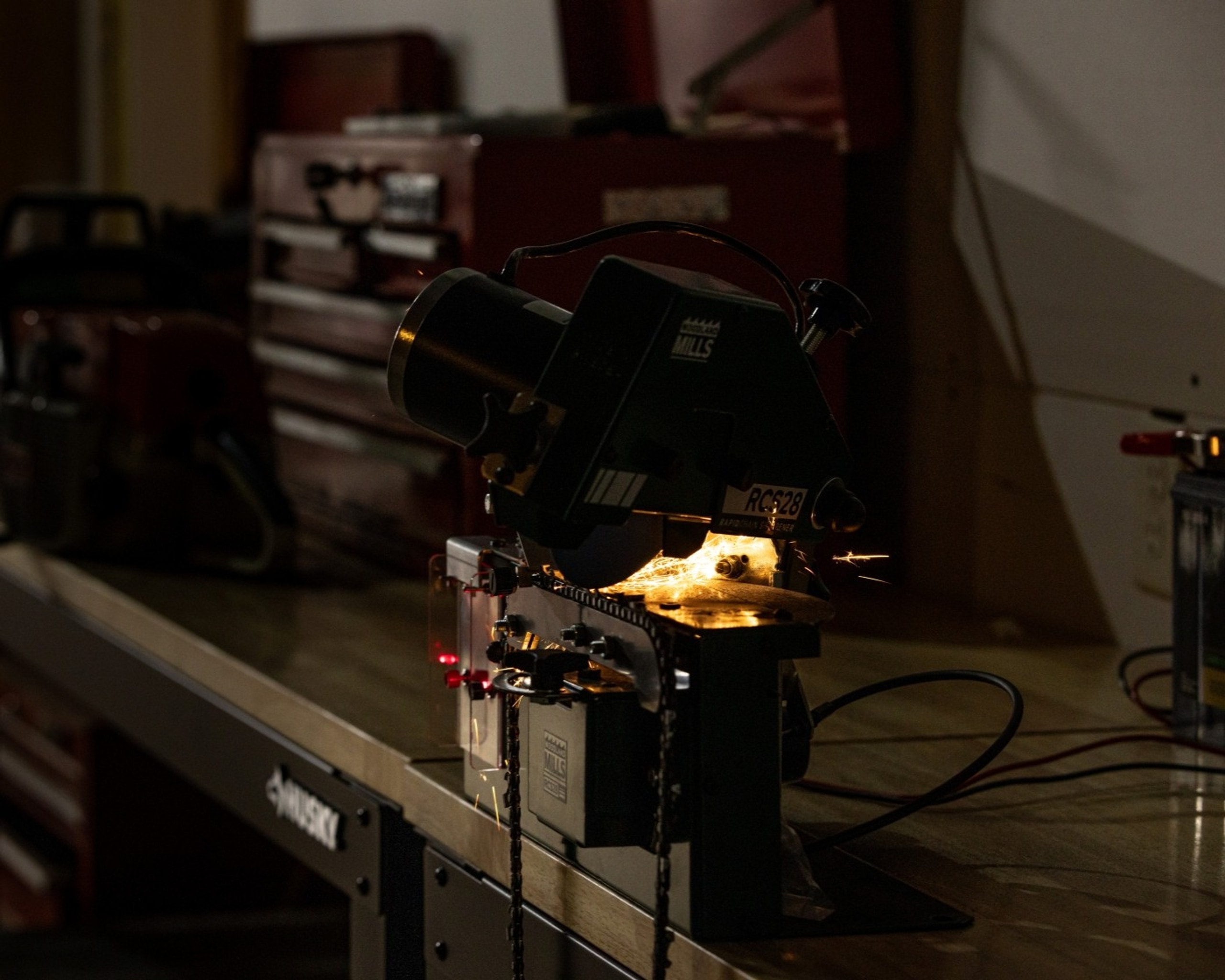 A Woodland Mills RCS28 Chainsaw Sharpener grinding the first tooth on a chainsaw chain. 