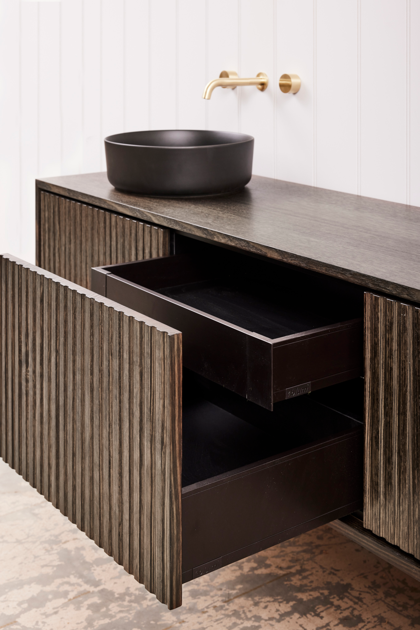 A Kariko Fenton timber bathroom vanity with two doors, and a centre drawer with a concealed second drawer inside