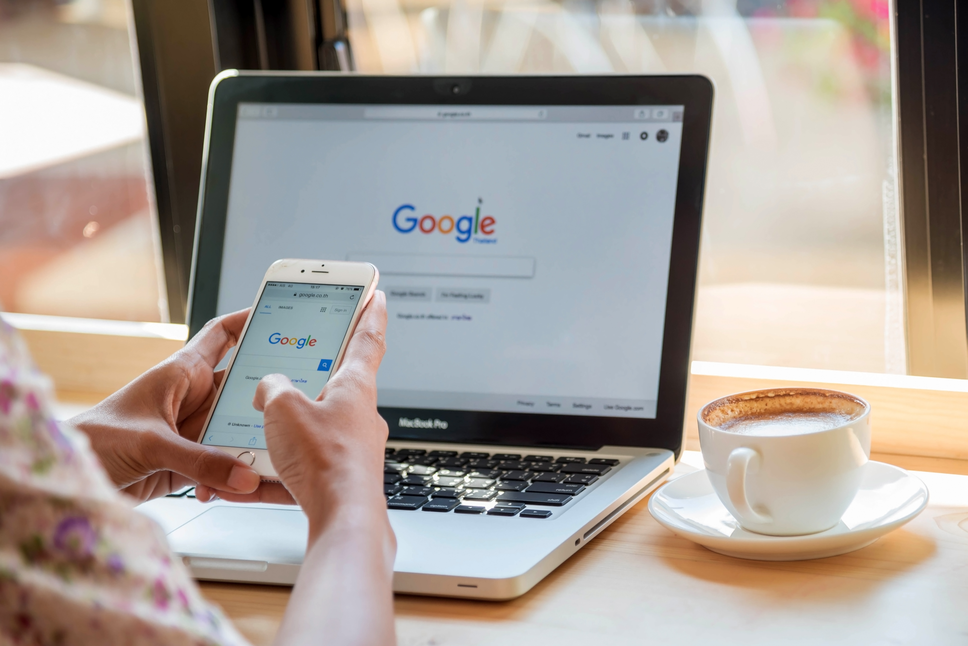 Woman using Google Search on mobile and laptop