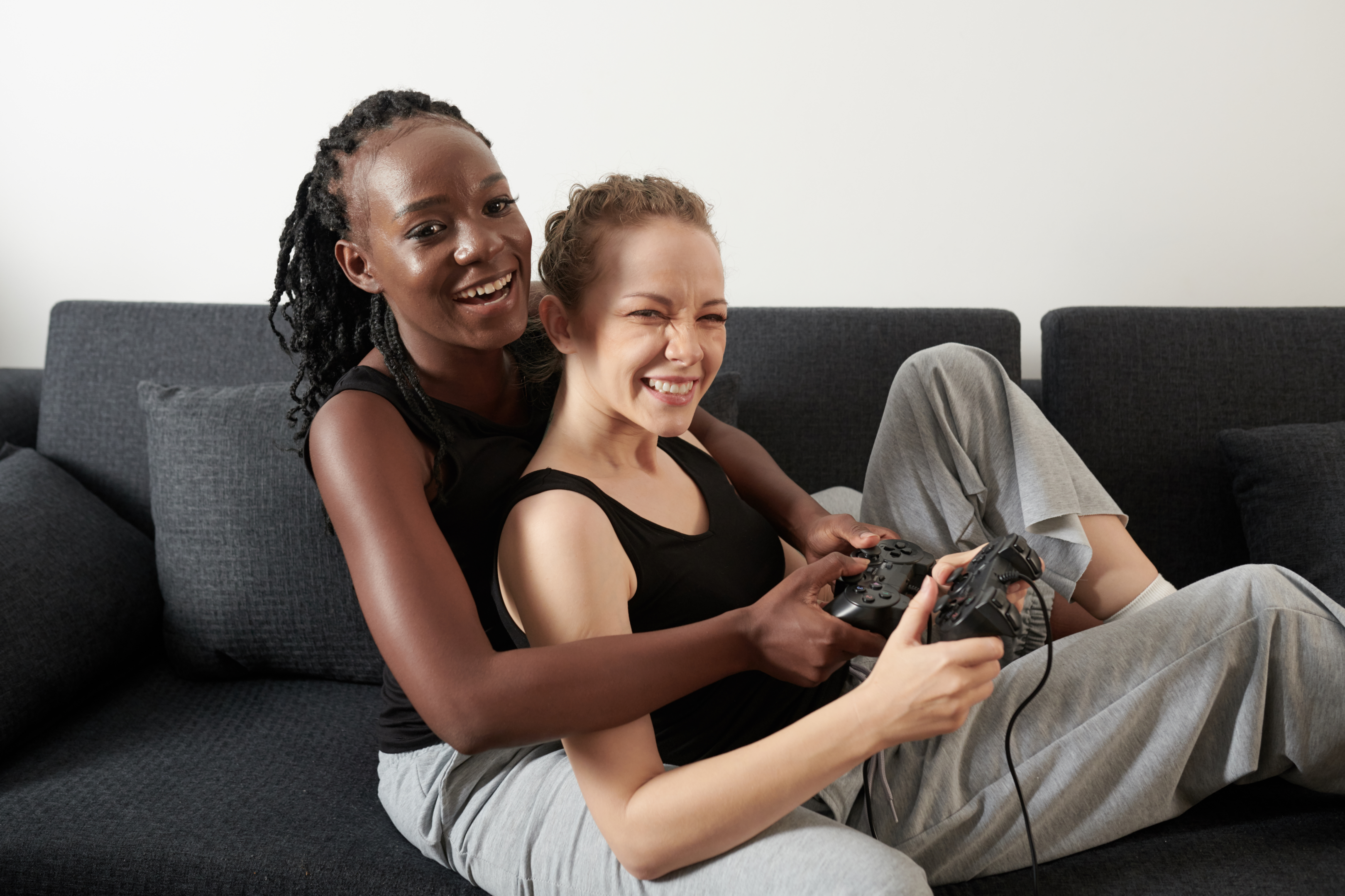 Couple playing a game on the couch in New York, navigating through booby traps associated with adult ADHD in relationships, fostering connection and teamwork as they overcome challenges together.