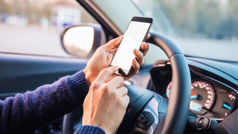 A woman is using the phone in the car which installed carbon tints.
