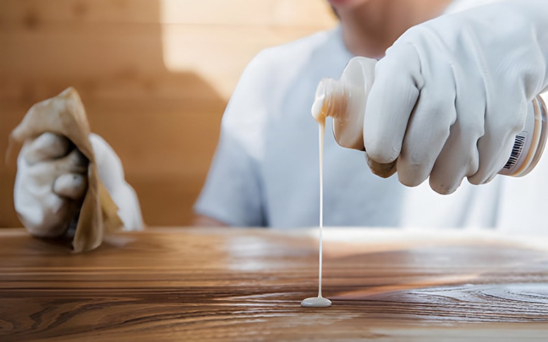 A man applying cleaning solution to wood furniture