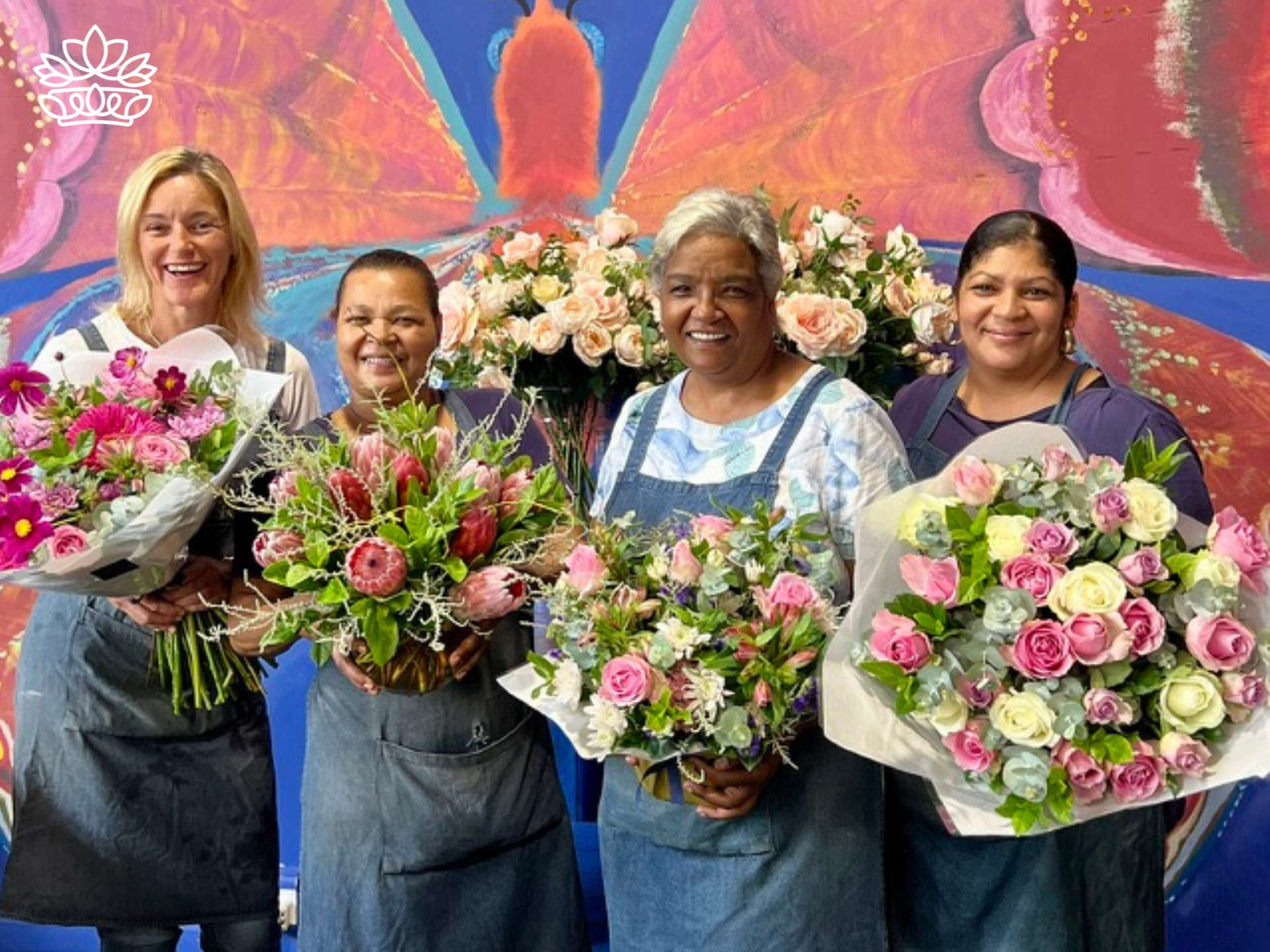 Four joyous florists presenting an array of splendid bouquets, bursting with fresh blooms in various hues, showcasing their floral artistry at Fabulous Flowers and Gifts.