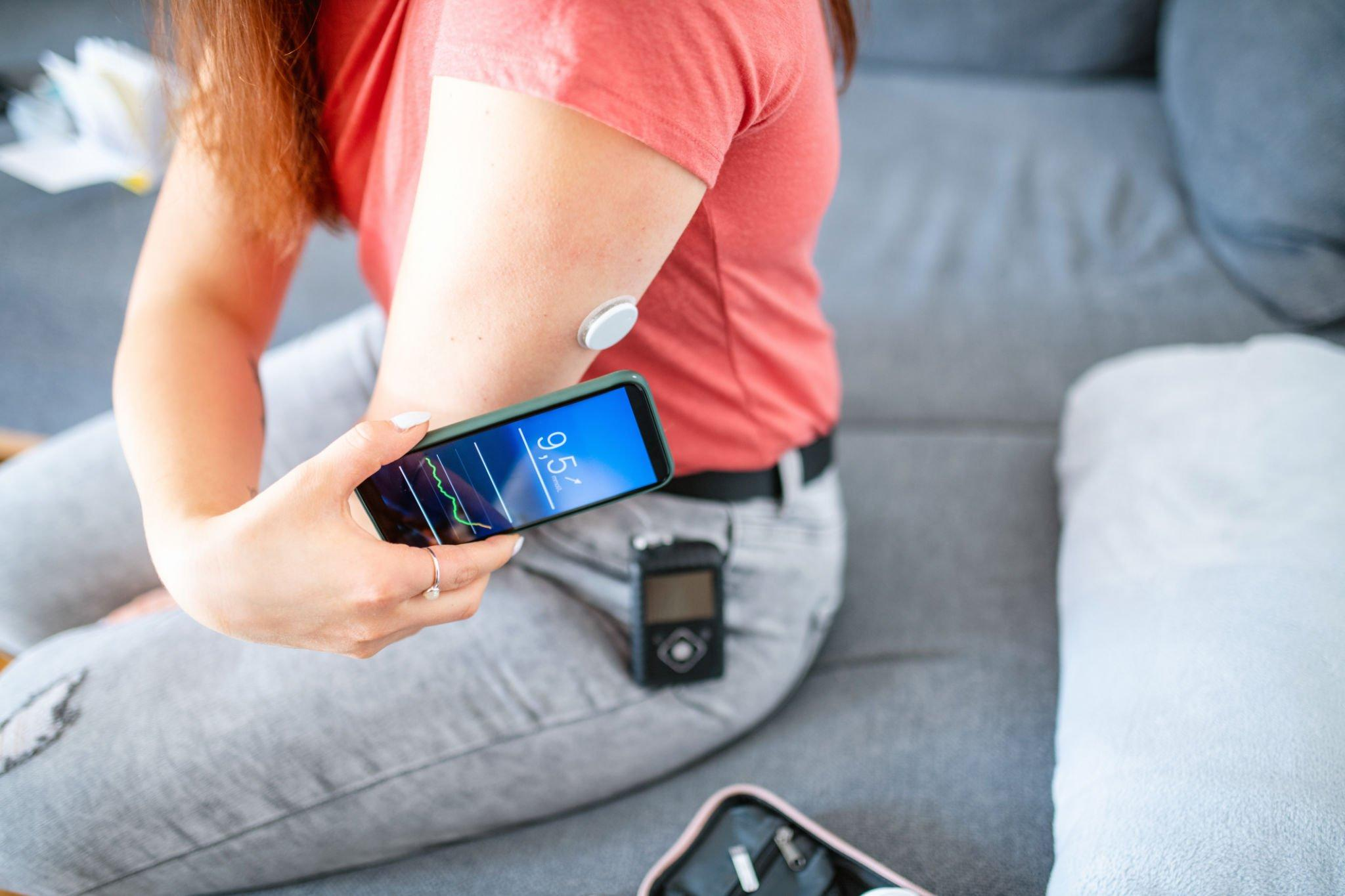 A woman scanning her CGM sensor to check glucose reading and monitor sensor values within her target glucose range