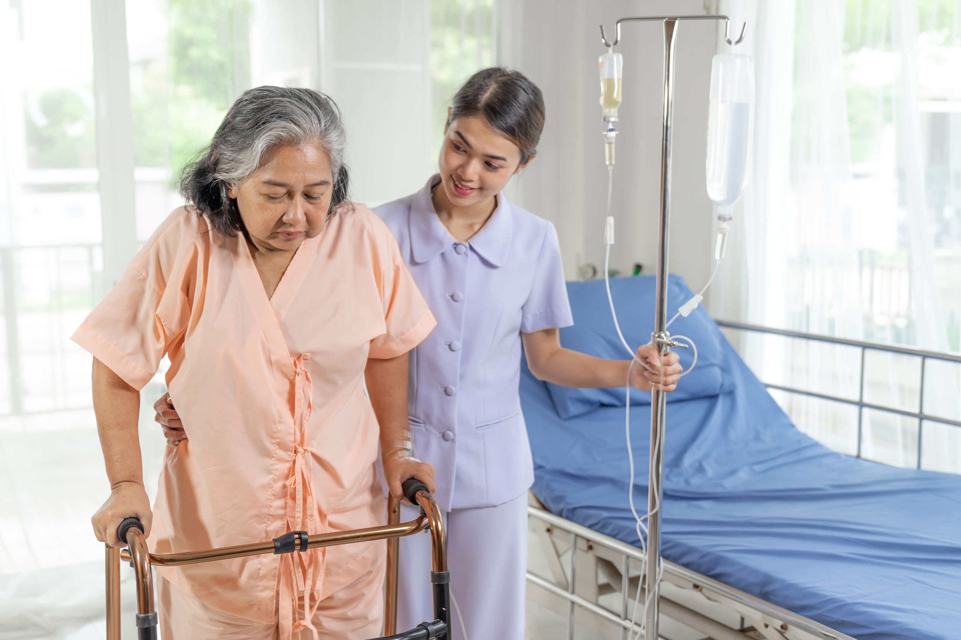 a woman walking in an assisted living facility being helped by a medical staff