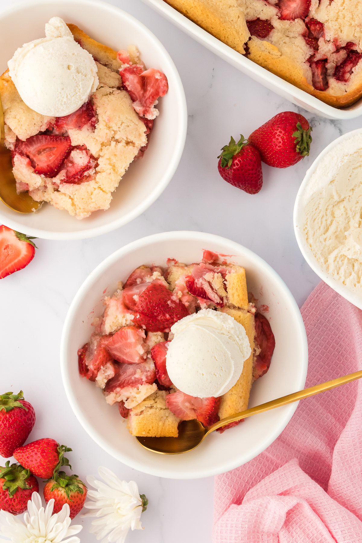 two bowls of strawberry cobbler topped with ice cream