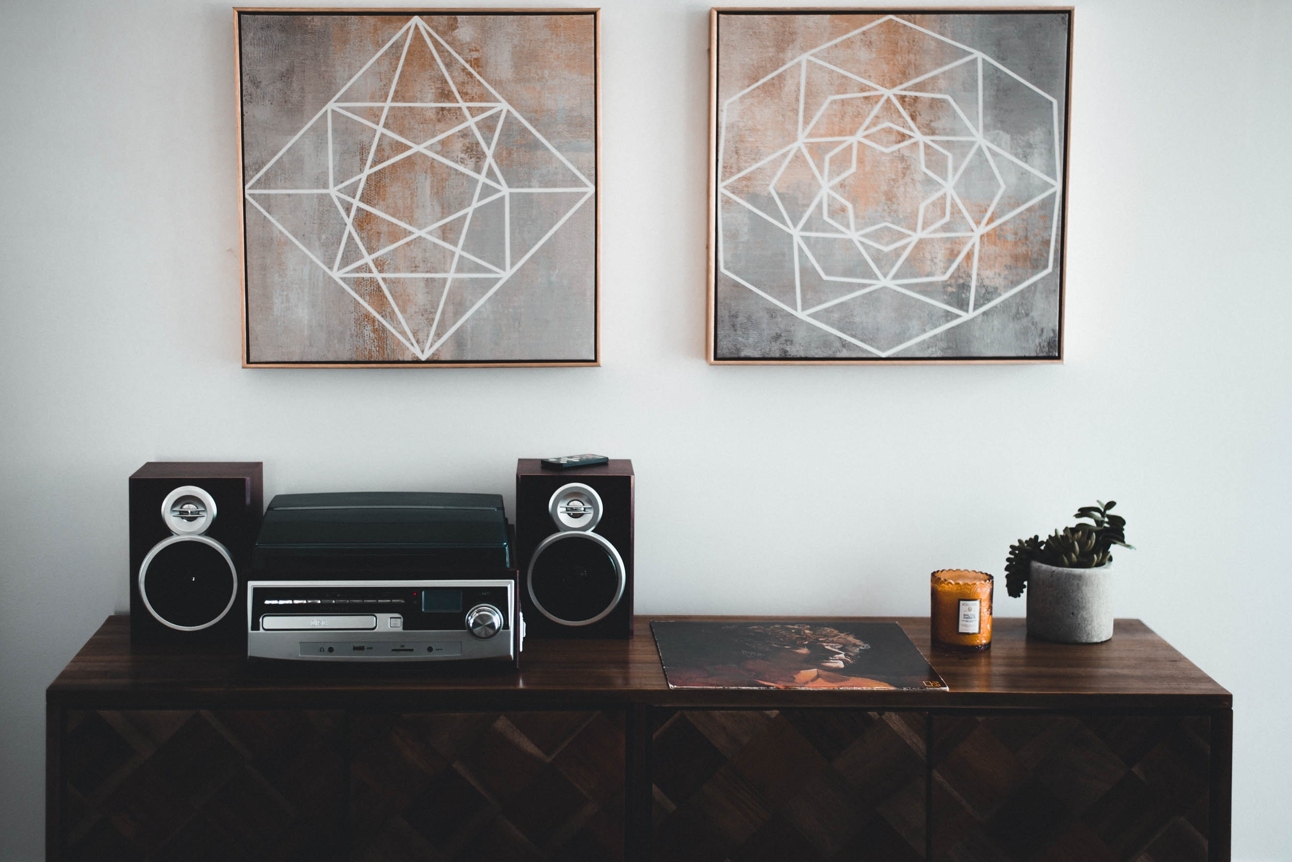 black stereo on console table with wall art