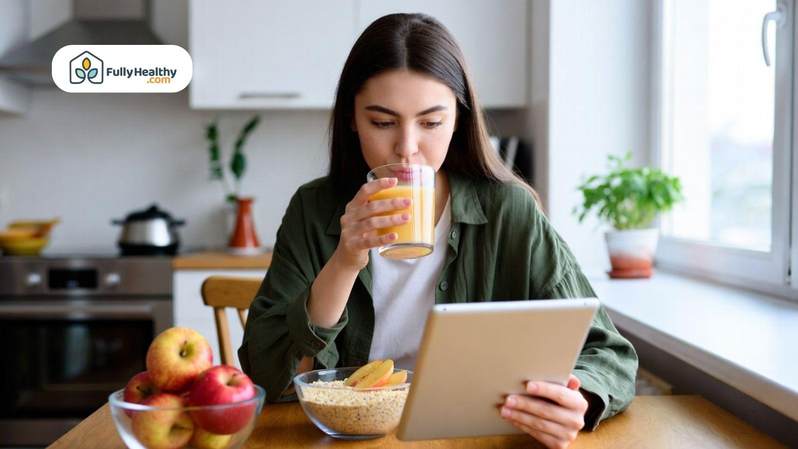 Woman drinking apple juice during a healthy breakfast at home.