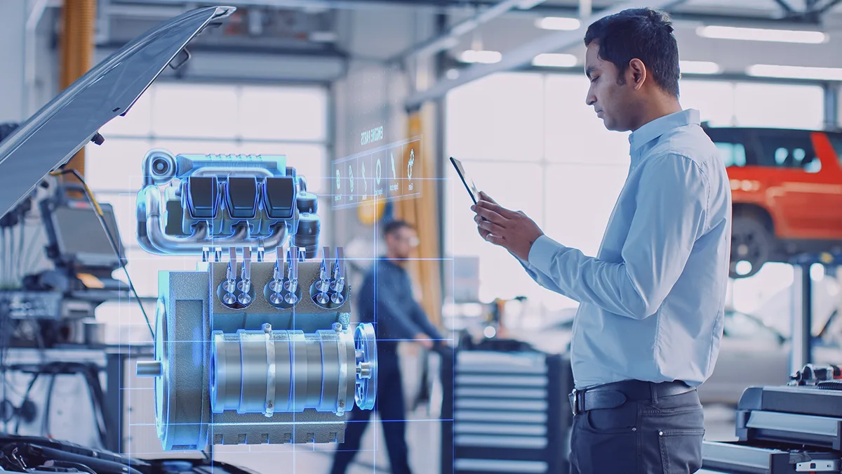Engineer using a tablet to analyze a virtual engine model with augmented reality in an automotive workshop
