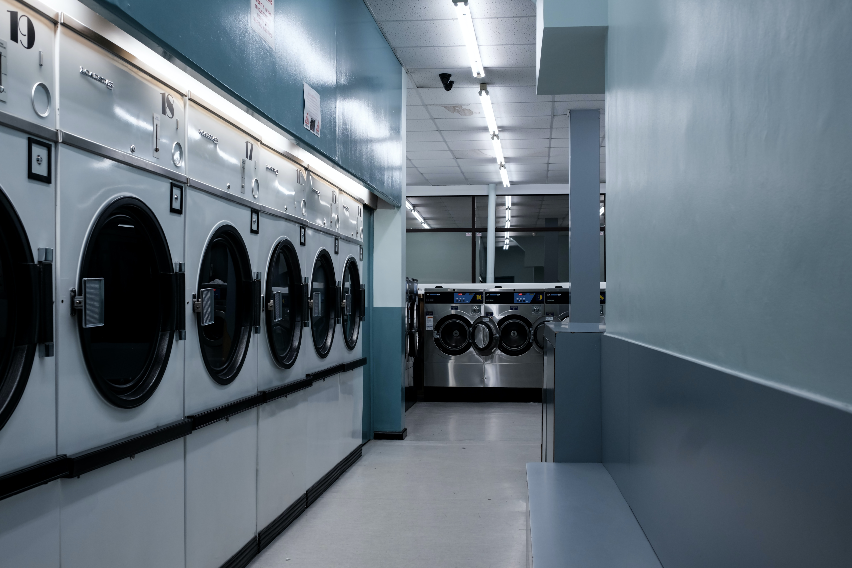 A local laundromat with multiple washers and dryers offering nearby apartment dwellers laundry services