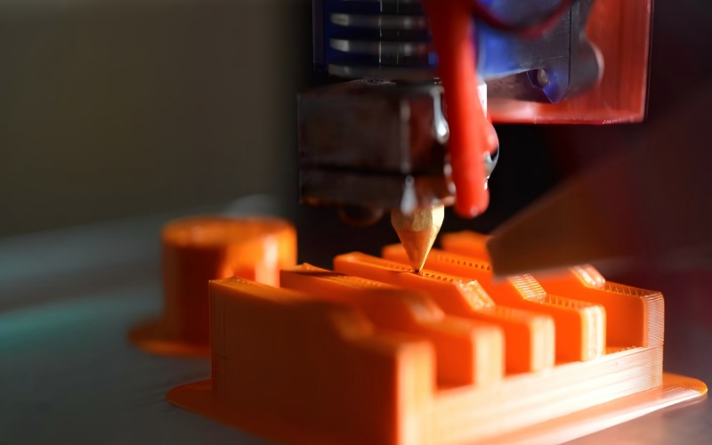 3D printer printing PLA filament releasing fumes in desktop workspace