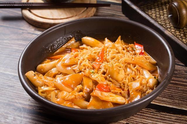 Tteokbokki with noodles in a plate on a wooden table.