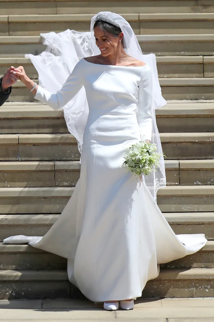 Meghan Markle Walking Down the Stairs with flowers in one hand and another hand taking Prince Harry's hand- Featuring Meghan Markle's Wedding Dress