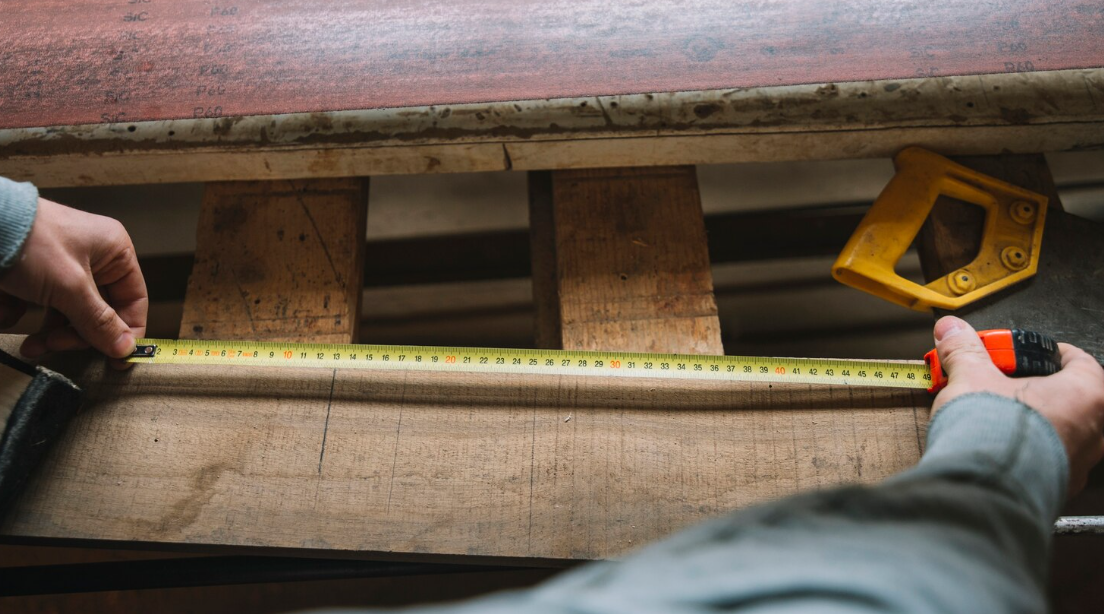 measuring a wood with a traditional measuring tape