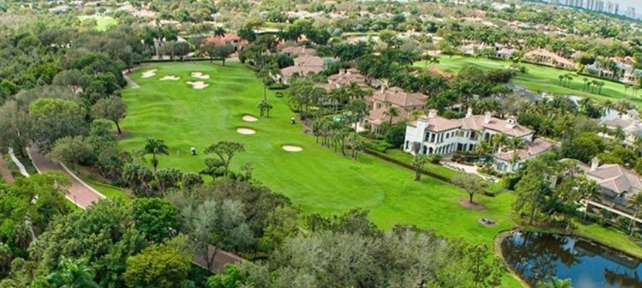 The image showcases a resort-style pool surrounded by lush tropical landscaping, offering serene views of a nature preserve. This inviting space is part of the Pelican Marsh community in Naples, Florida, known for its luxurious amenities and proximity to premier golf clubs and Vanderbilt Beach.