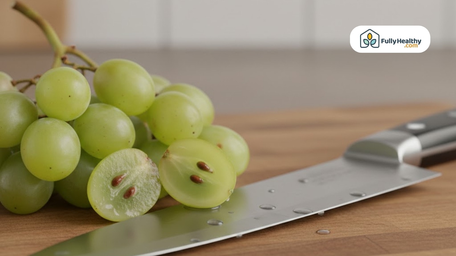 Halved green grapes showing seeds beside kitchen knife on wooden surface