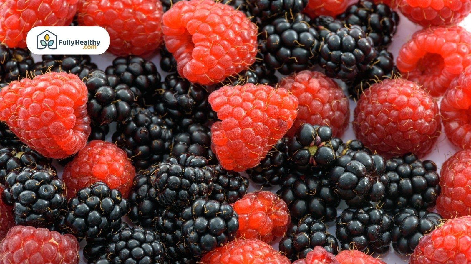 Fresh raspberries and blackberries mixed together in close-up view