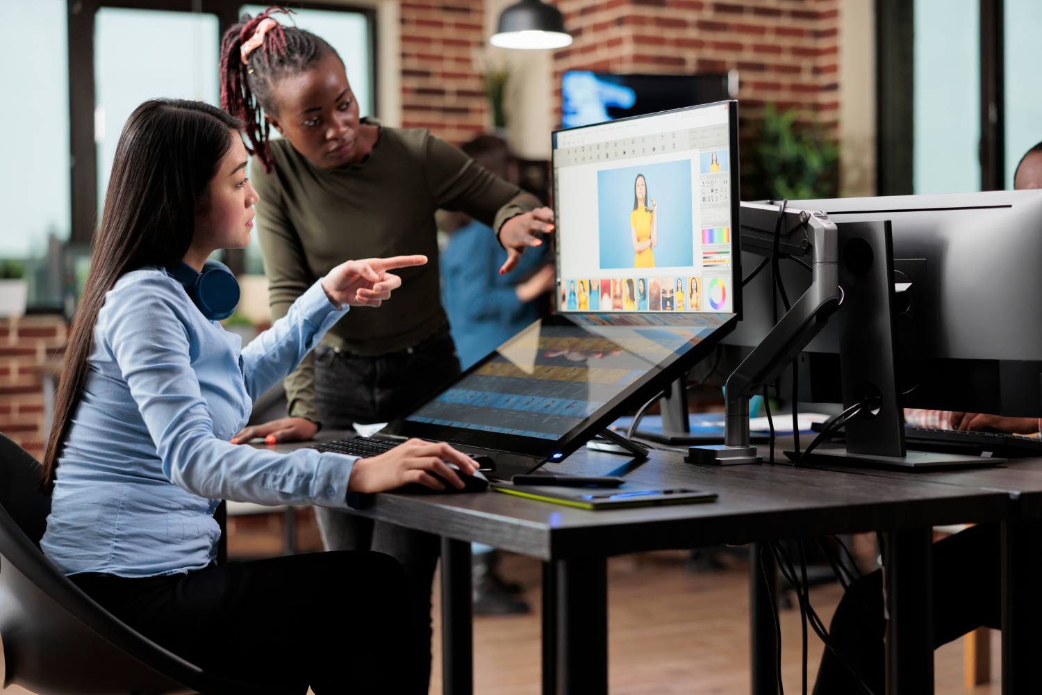 Two colleagues looking at desktop.