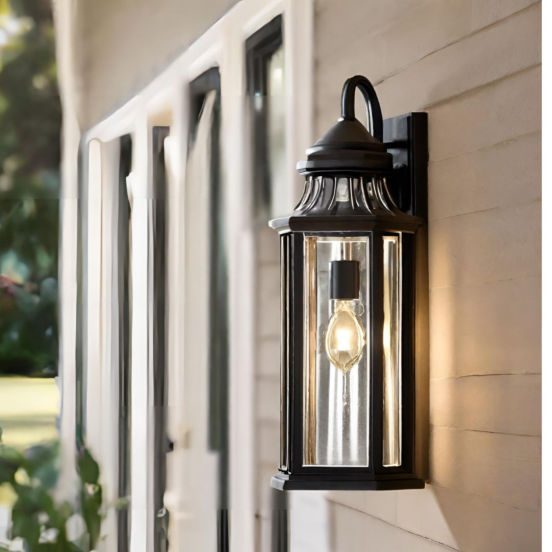 A wall light with sensor featuring a retro design with a glass frame and a downturned light mounted on a wall outside a home.