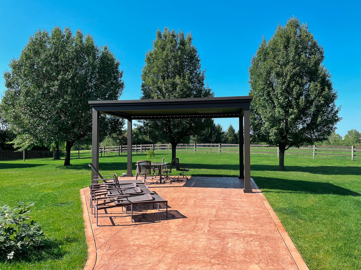 freestanding pergola installed over a patio with outdoor seating.