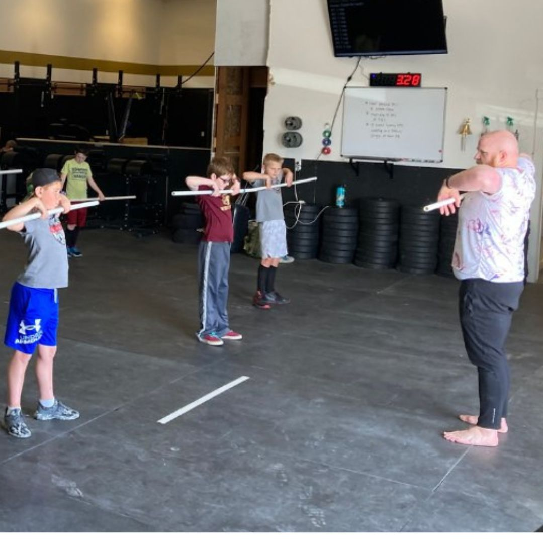A group of children doing CrossFit exercises at one of the crossfit gyms near me