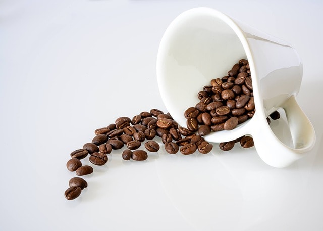 Coffee beans spilling out of a cup