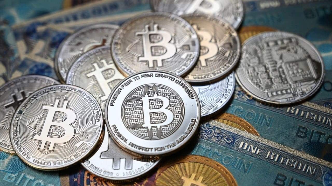 مجموعة من عملات البيتكوين المعدنية فوق أوراق نقدية رمزية