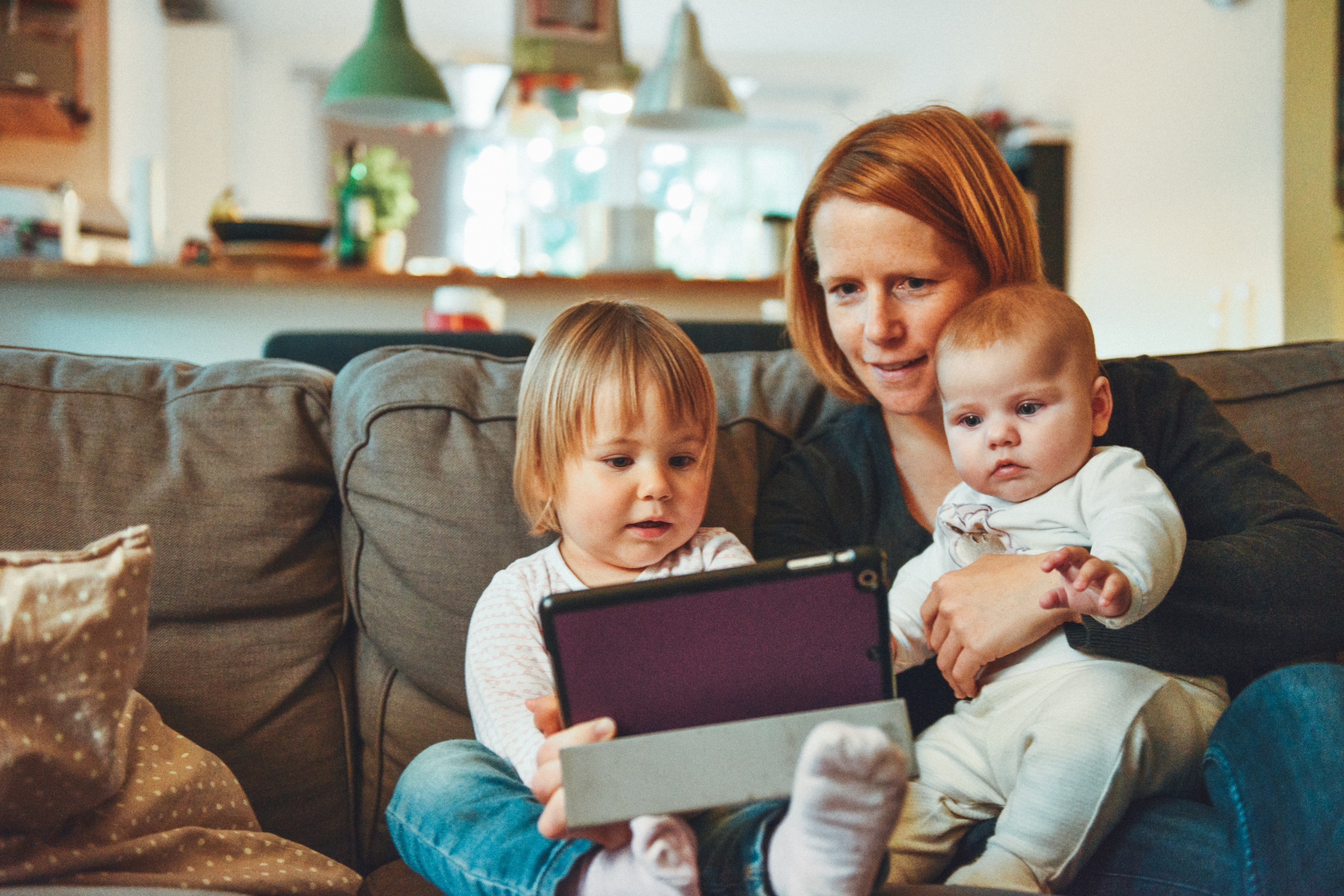 A mother with her children looking at a tablet device