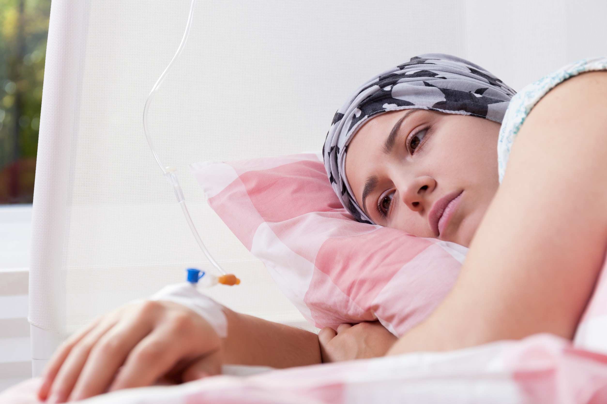 A woman suffering from ovarian cancer symptoms such as abdominal pain lays in a hospital bad