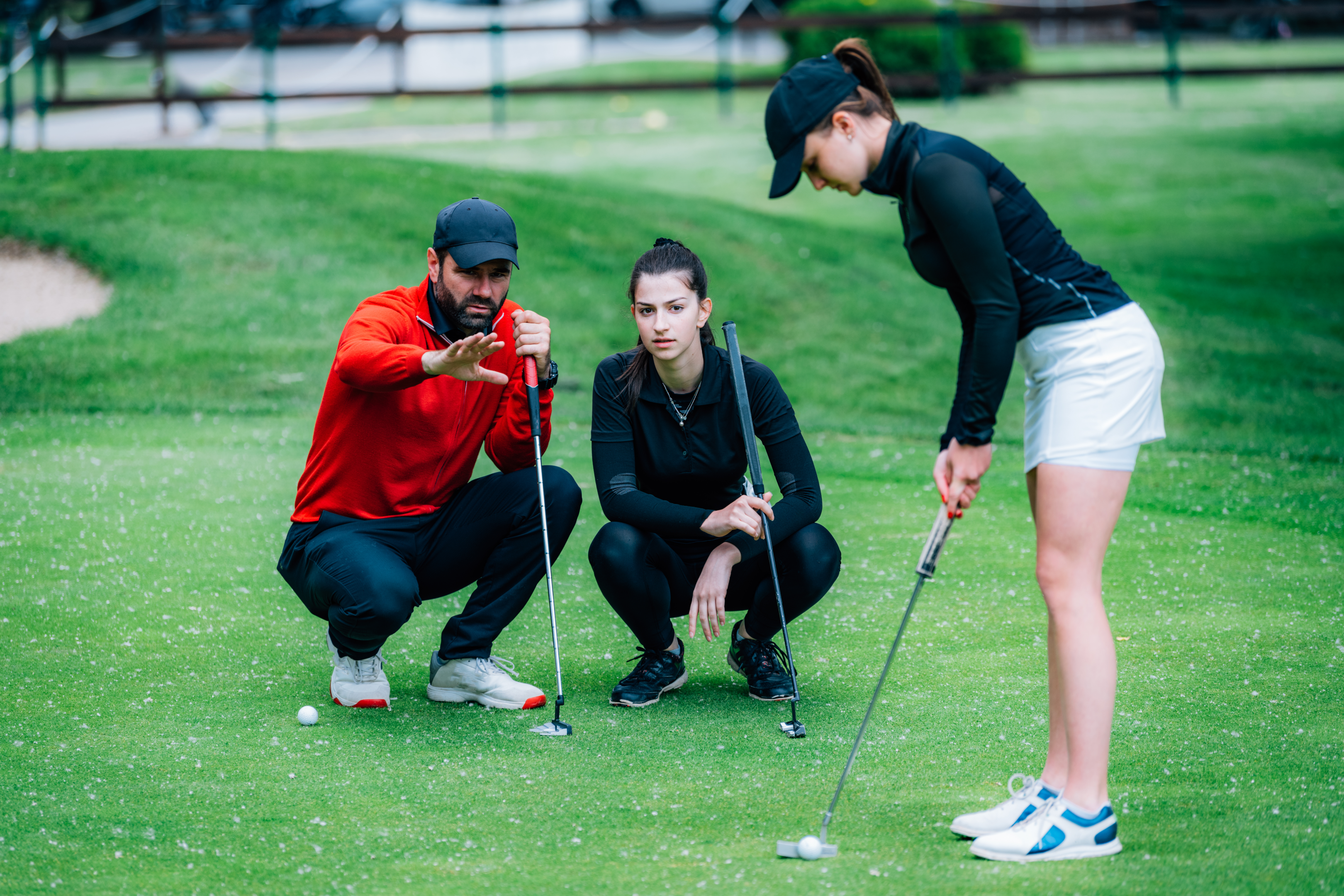 golf coach checks how well a student hits the ball