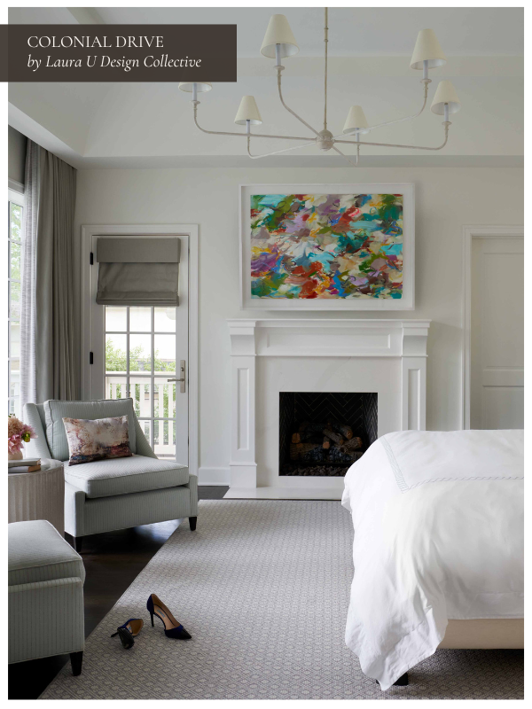 all white Neoclassical fireplace that acts as the focal point of the primary suite under high ceilings and white walls