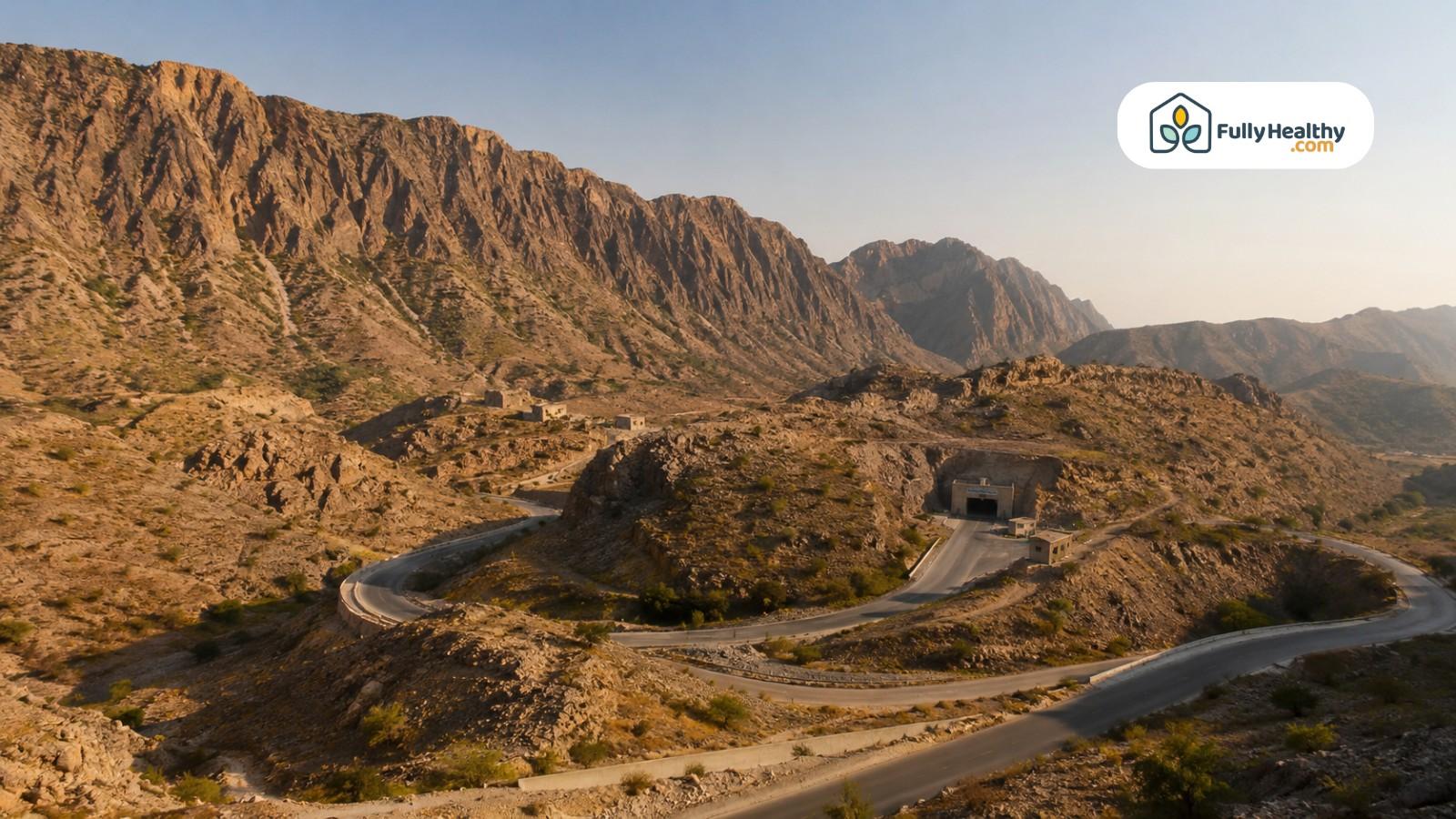 Rocky Salt Range landscape with winding road leading to a distant mine entrance