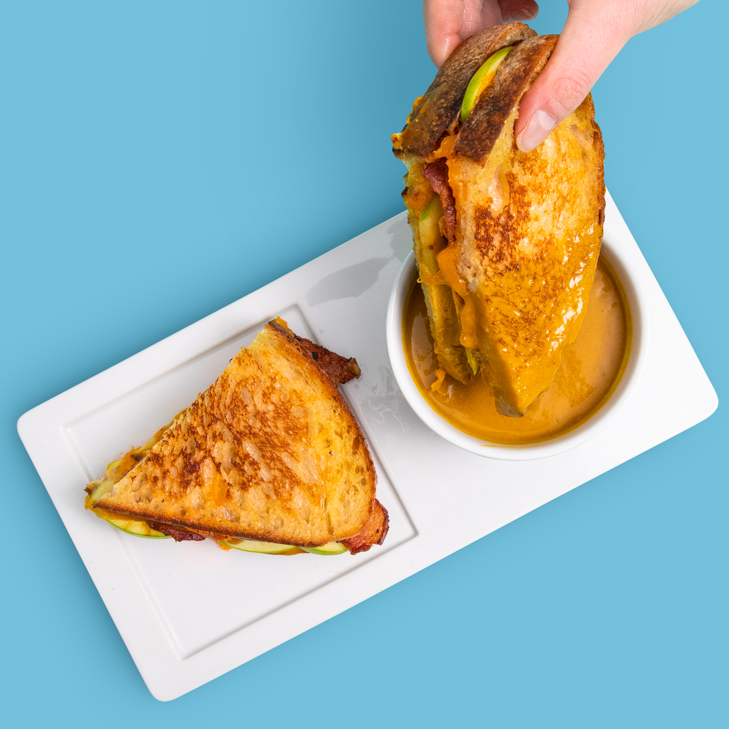 A grilled cheese with avacado, fresh mozzarella, wheat bread, and Proper Good's Butternut Squash Soup