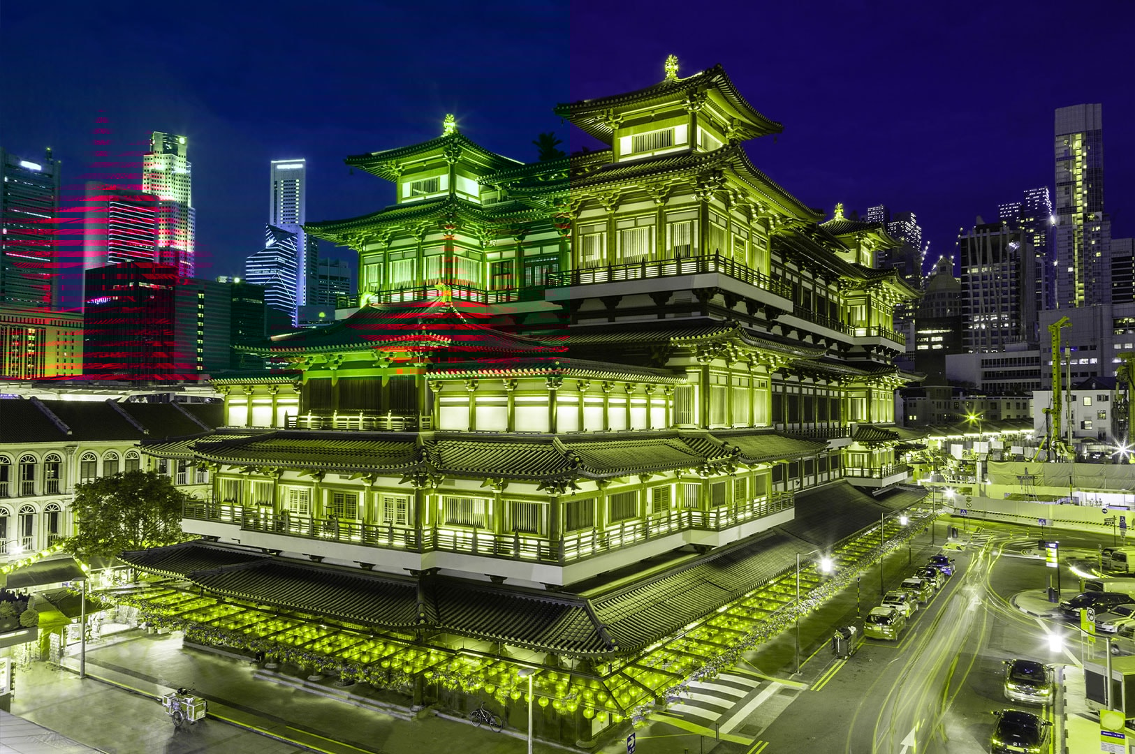 Stunning night view of the illuminated Buddha Tooth Relic Temple and Museum in Singapore's Chinatown, surrounded by modern skyscrapers.