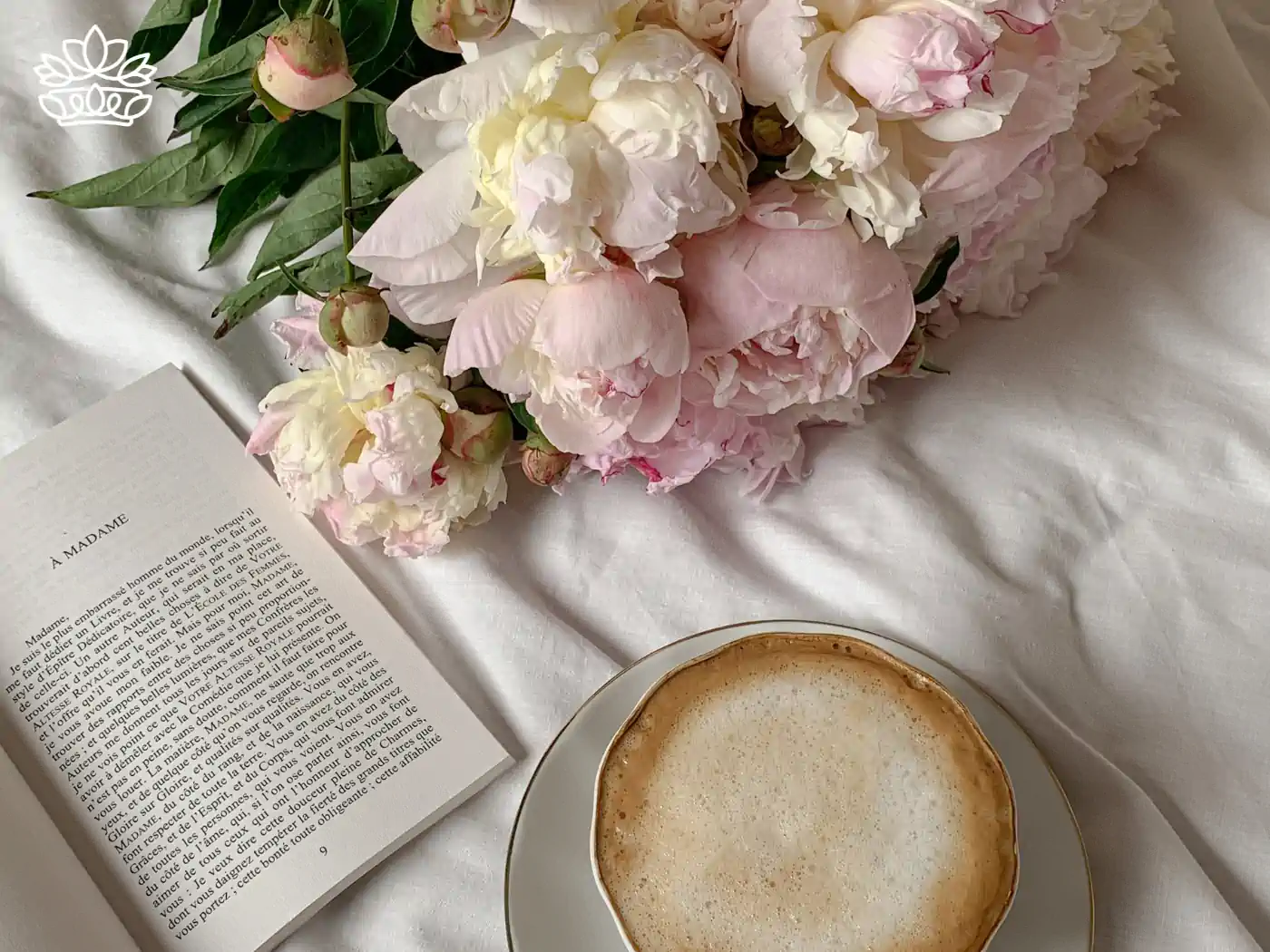 A cozy setting with a bouquet of peonies, a book, and a cup of coffee on a white blanket. Fabulous Flowers and Gifts - Peonies Collection