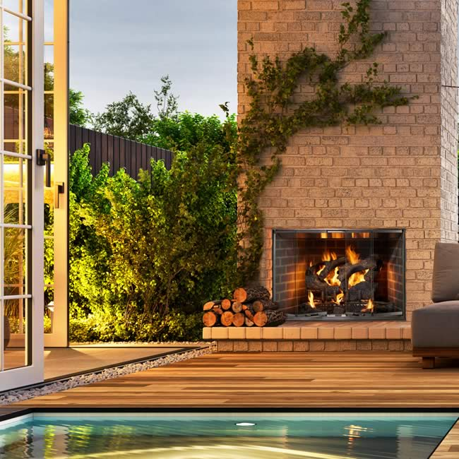 Modern outdoor fireplace with a stone wall and a metal bench