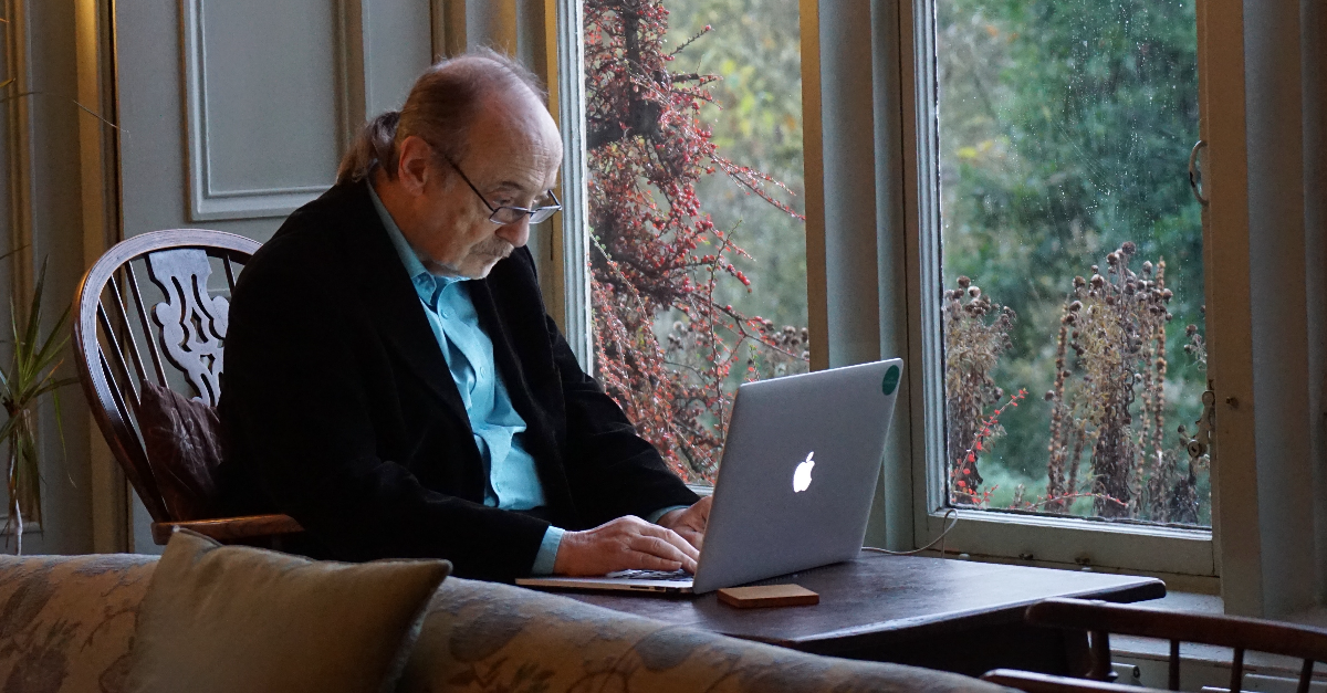 Man zit voor een laptop en kijkt naar het scherm.