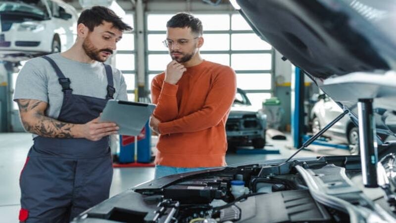 A professional sharing the cost for headlight replacement with a car owner.