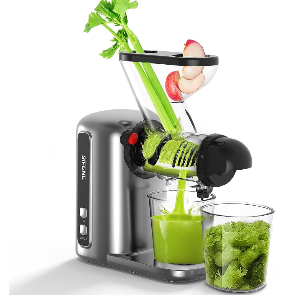 A masticating juicer with fruits and vegetables in the background, extracting juice from celery stalks and other soft fruits