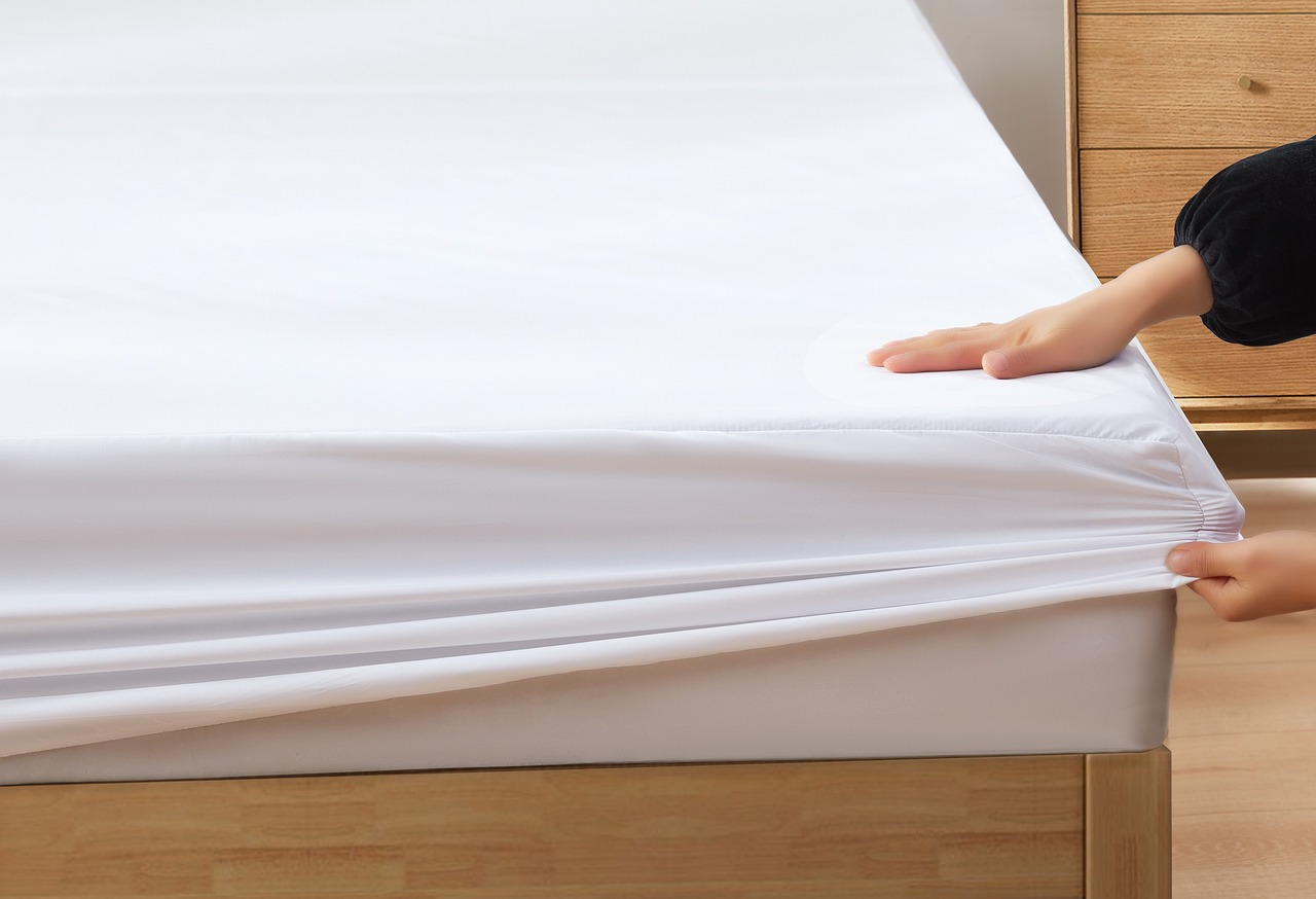 An image of a person putting a dust mite cover on a mattress. 