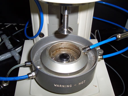 A picture of asphalt binder sample being tested in a dynamic shear rheometer